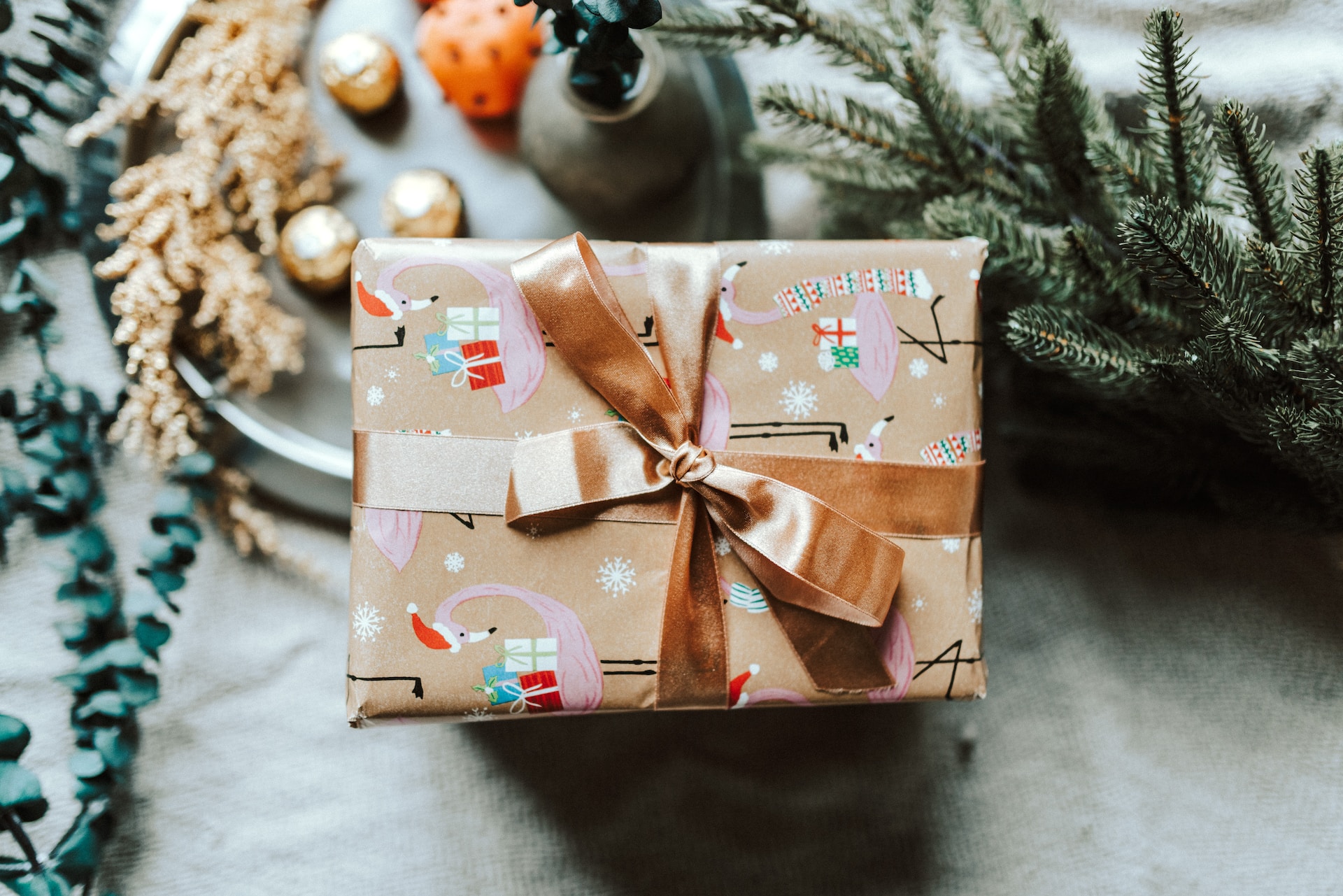 A present wrapped up in decorative wrapping paper with gold ribbon tied around. 