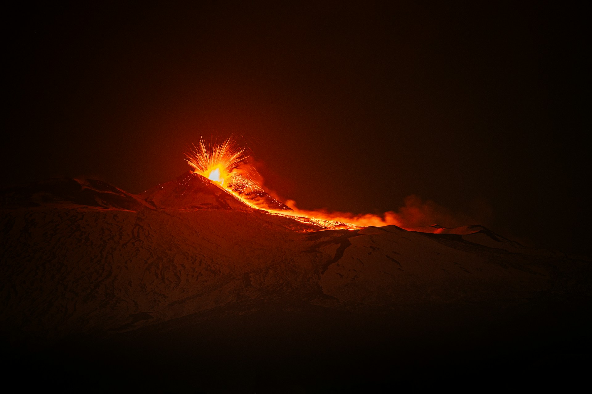 Shot of Mount Etna erupting in the night.
