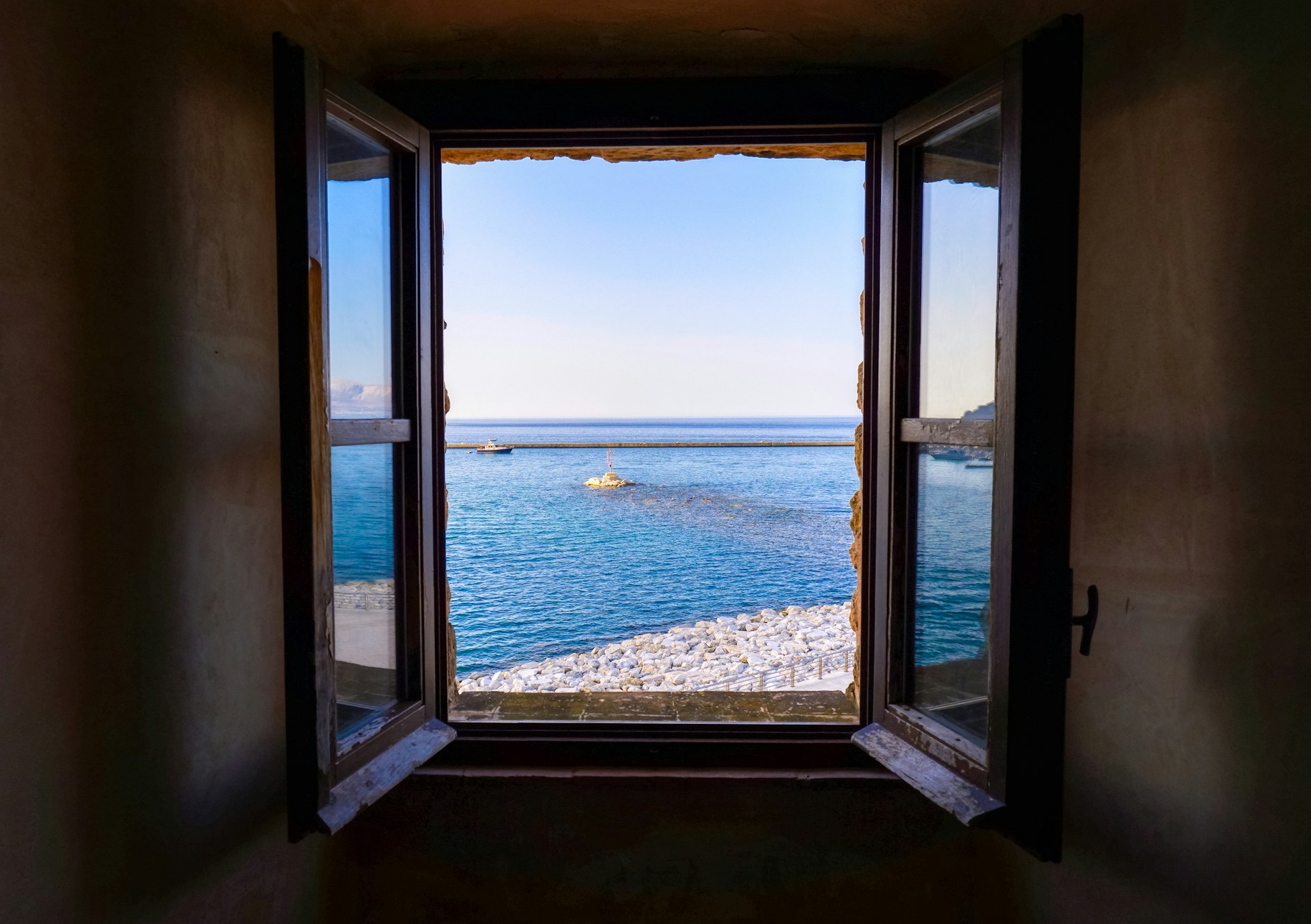 View of the sea through old window frame. 