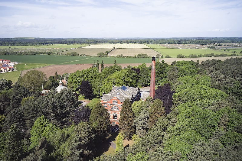 Aerial shot of The Pumping House in-between the trees.