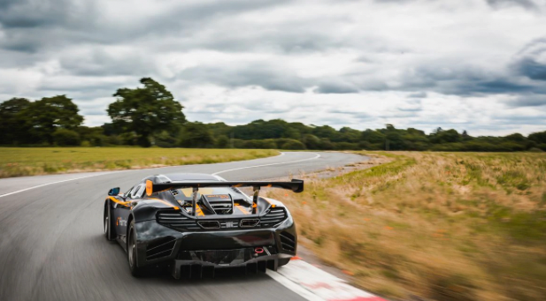 Image of black McLaren driving around a race track. 