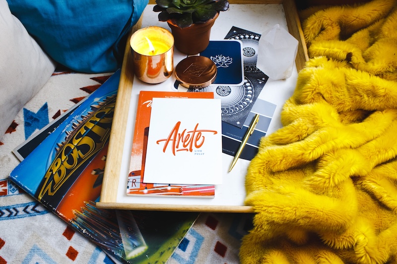 A fluffy yellow blanket on a bed with magazines. 