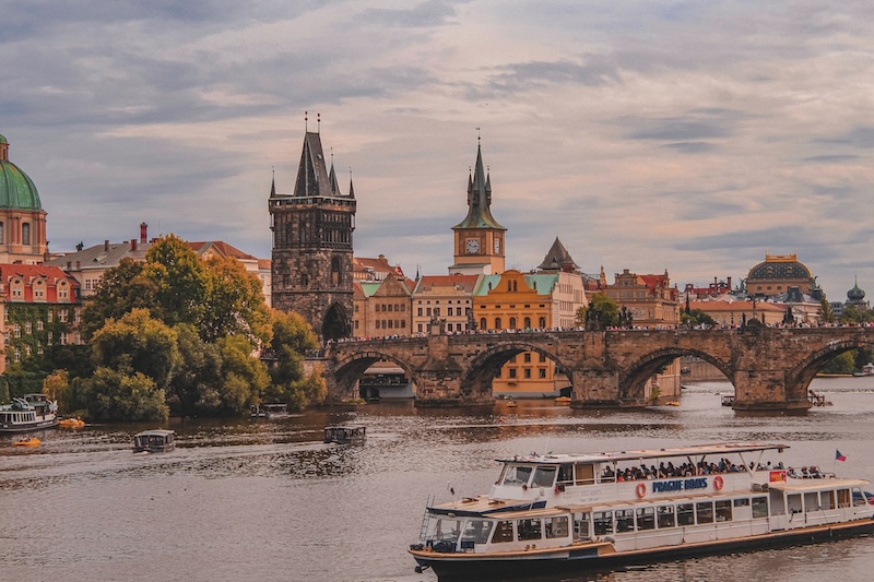 View of Prague city at sunset with the Vltava river in the forefront. 