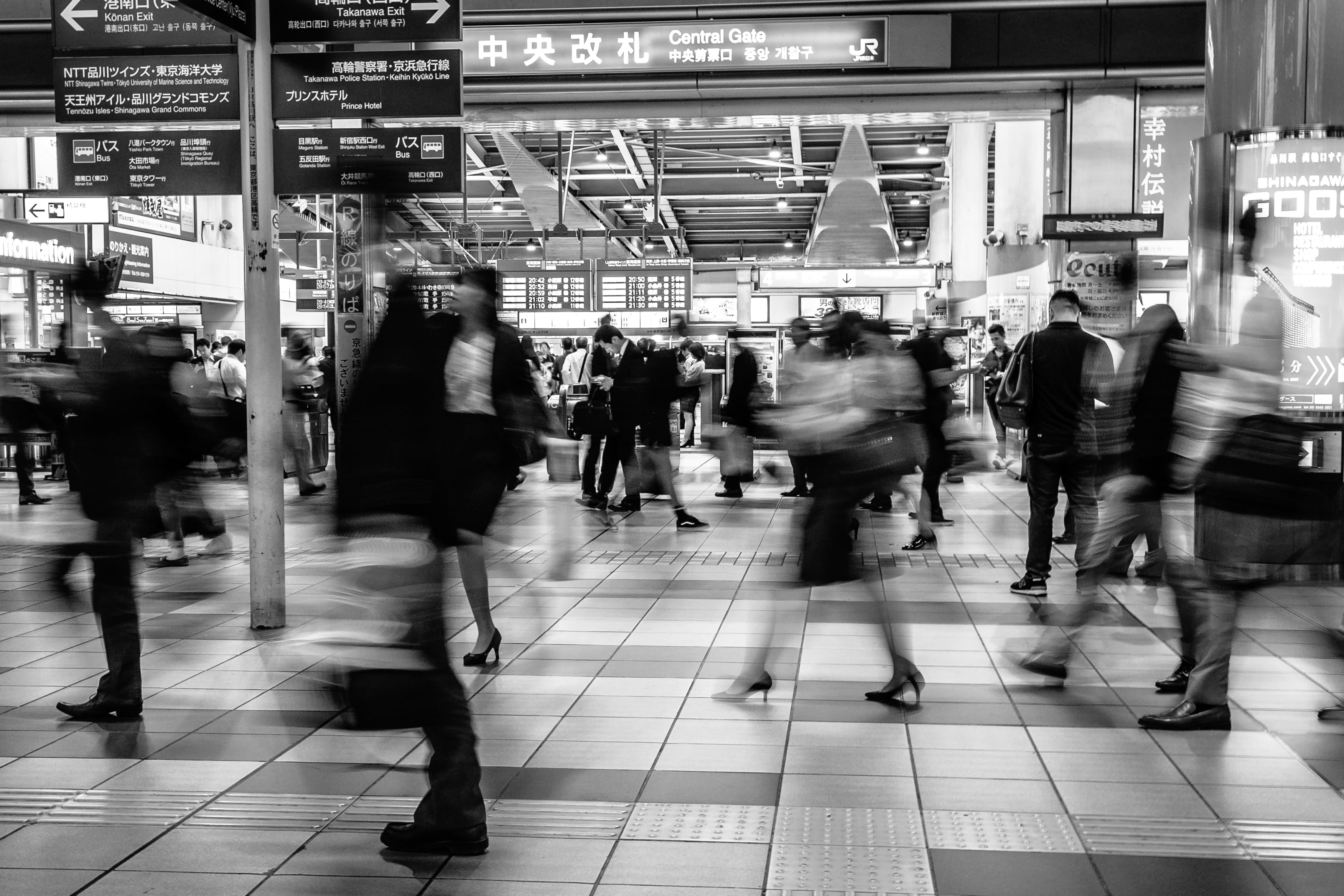 Black and white image of commuters rushing in Shinagawa Station, Japan. 