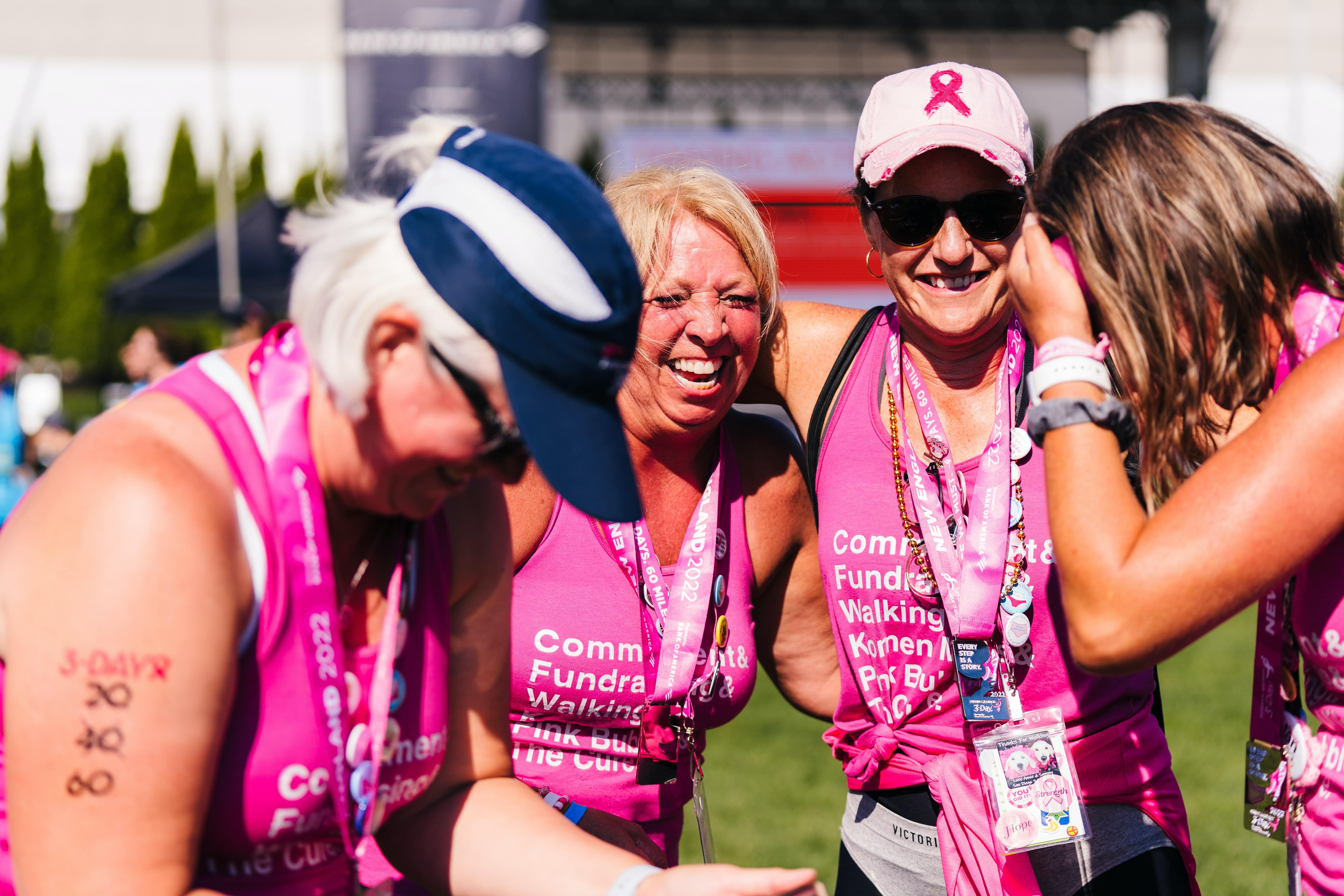 Four women laughing together after completing charity fun run. 
